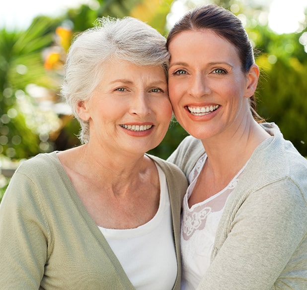 mother and daughter smiling outside