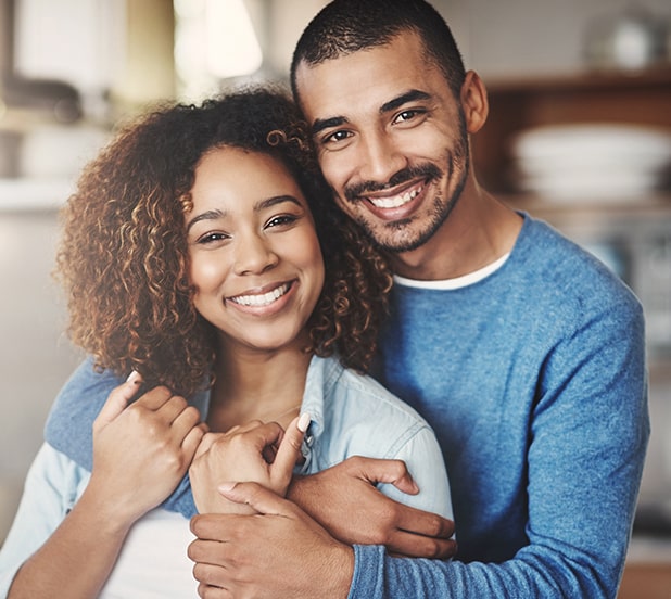 young couple smiling while hugging