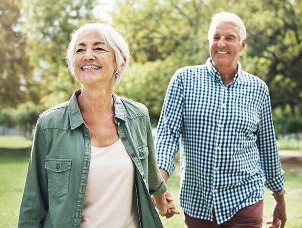 Older couple outside smiling in the park