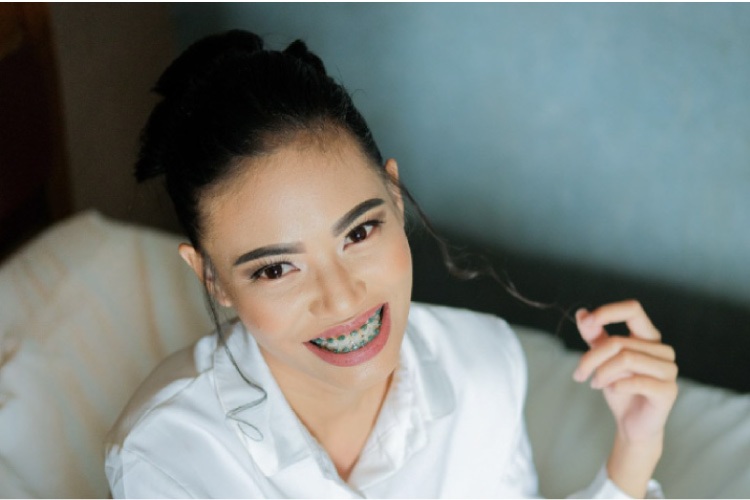 young girl twirling her hair wearing braces on her teeth