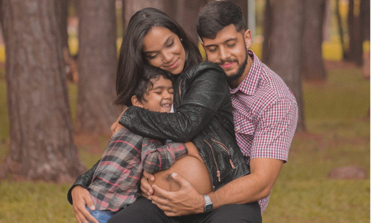 pregnant woman hugging with husband and son