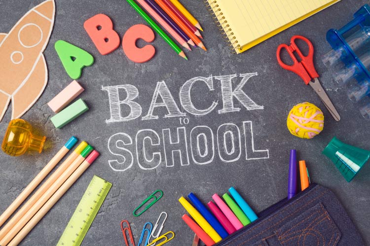 Aerial view of chalkboard with BACK TO SCHOOL surrounded by miscellaneous school supplies