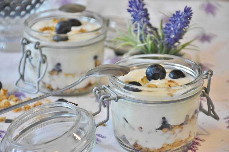 Low-sugar yogurt in a glass container with blueberries and granola