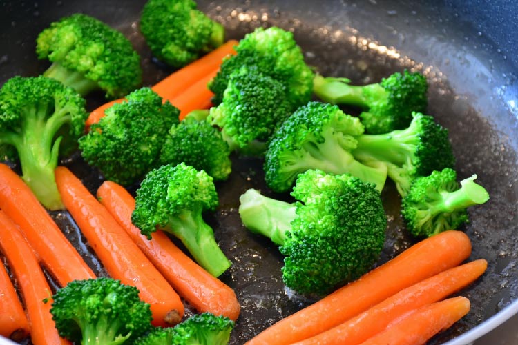 Broccoli and carrots with vitamin A cooking in a cast-iron skillet
