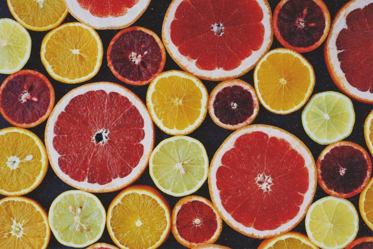 Aerial view of various slices of citrus, including grapefruit, lemon, lime, and orange