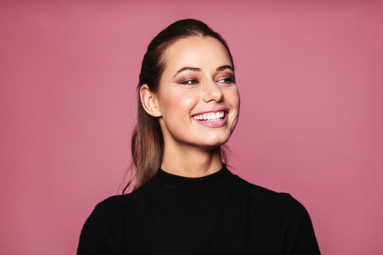 Brunette woman smiles with a white smile in 2020 after ZOOM in-office whitening at Hillstream Dental