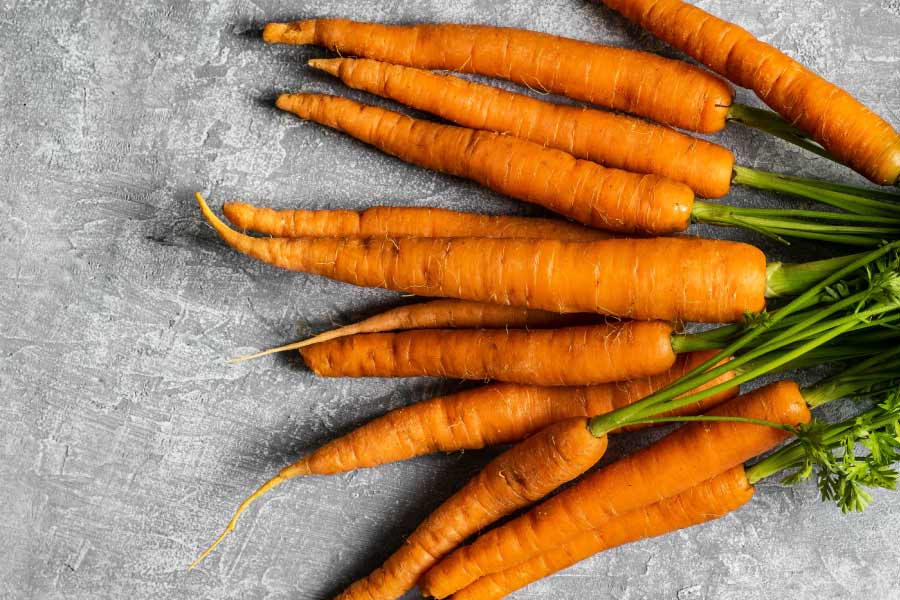 Aerial view of a bundle of green and orange carrots