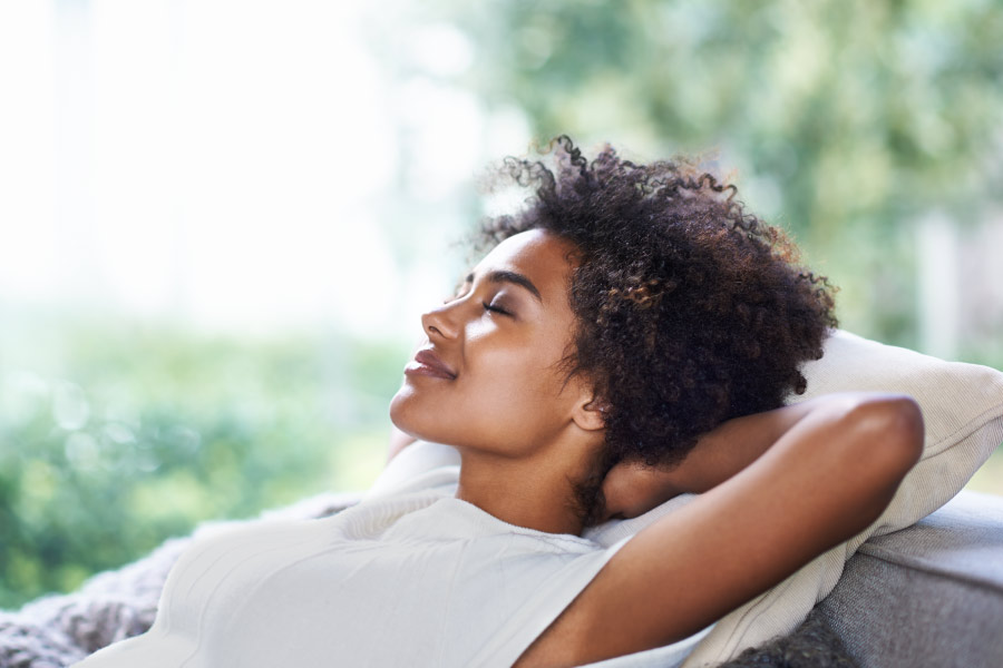 Pretty young black girl relaxing on the patio with her eyes closed