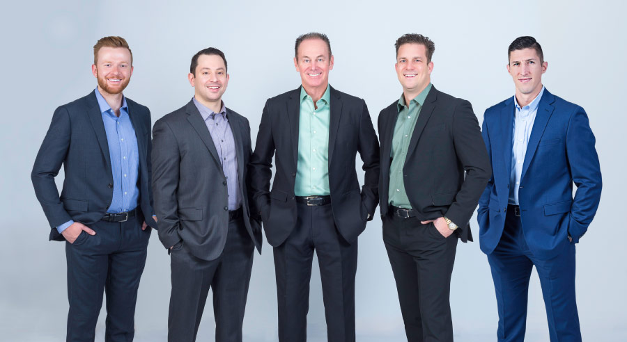 Five Hillstream dentists dressed in dark suits standing side by side