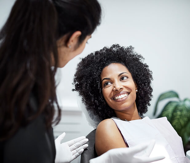 smiling woman speaking with her dentist