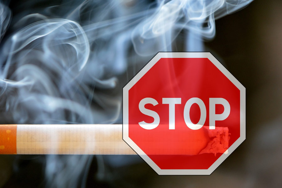 A red stop sign superimposed over a smoking cigarette