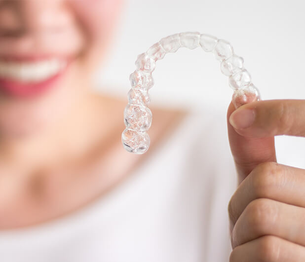 closeup of a person holding a clear aligner