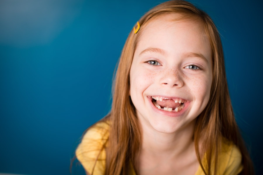 Smiling little girl with missing teeth.