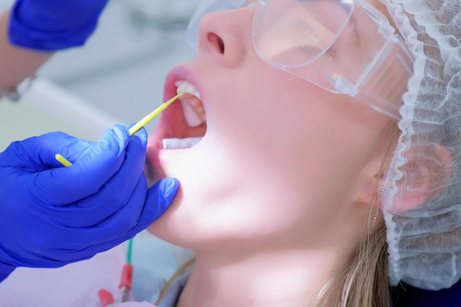 Woman in the dental chair getting a fluoride treatment.