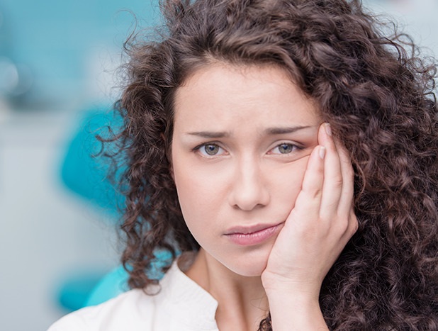 woman holding her jaw in pain